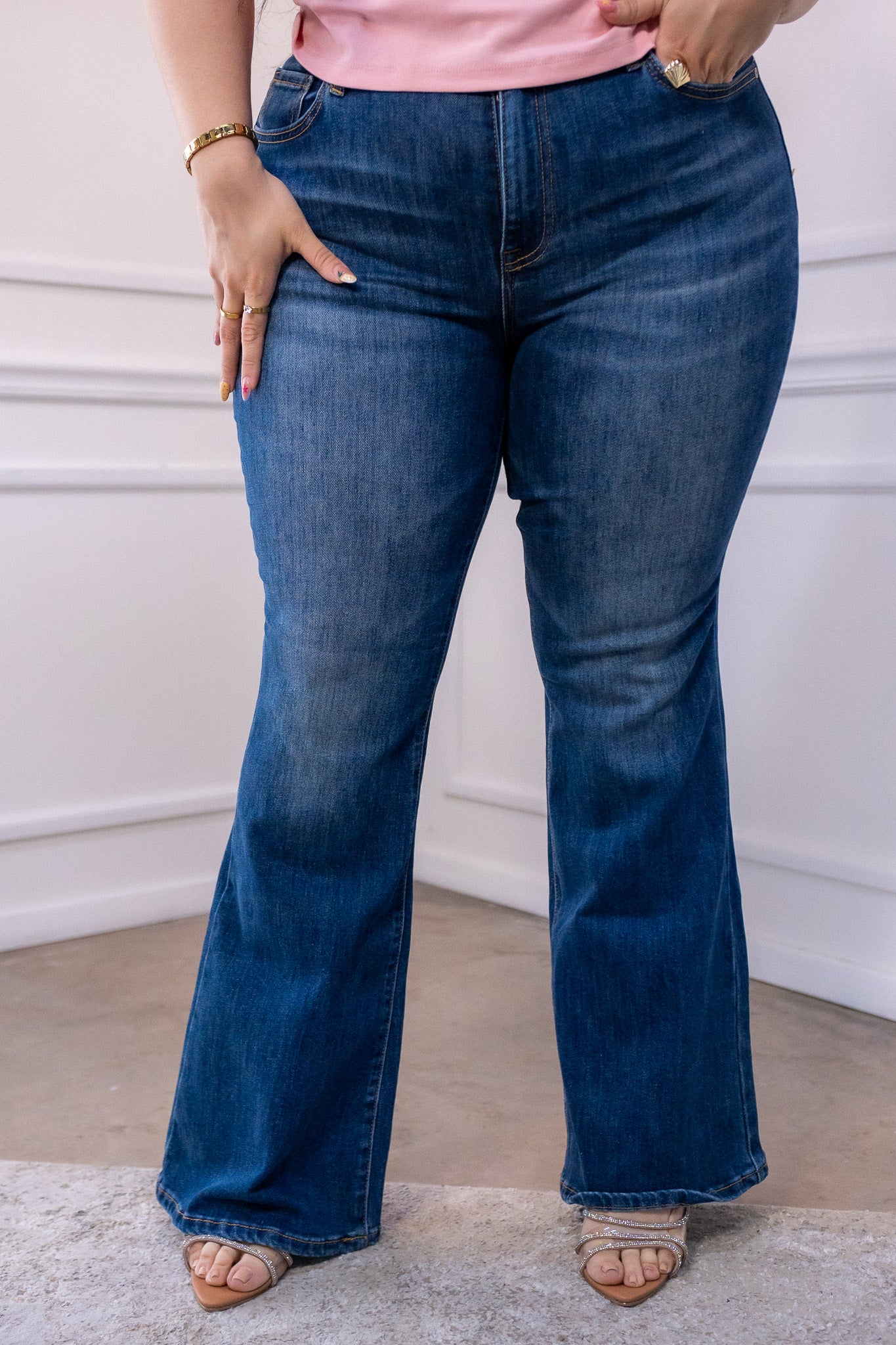 Modelo curvy usando jeans de mezclilla stretch corte campana y cintura alta, talla extra plus size