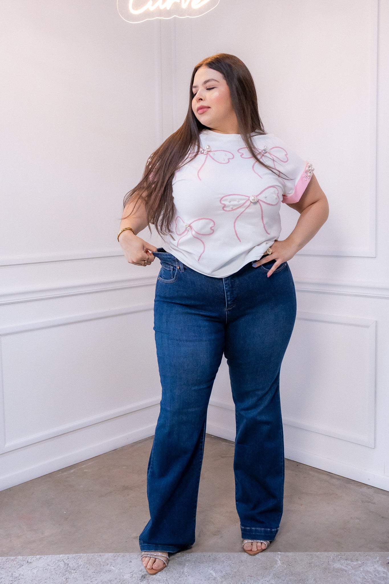 Modelo curvy usando jeans rectos oscuros tiro alto con stretch, talla extra plus size