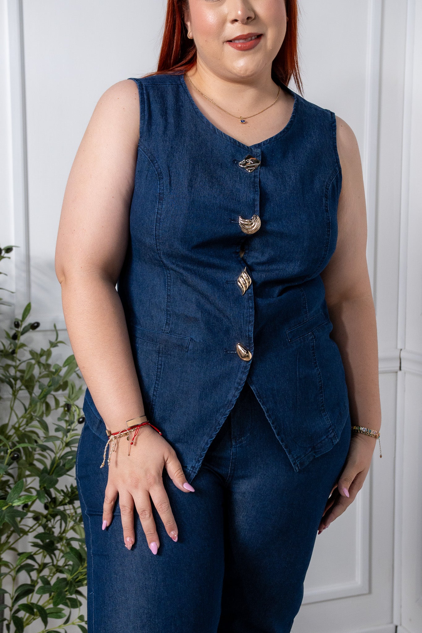 Modelo plus size usando chaleco de mezclilla con botones, talla extra