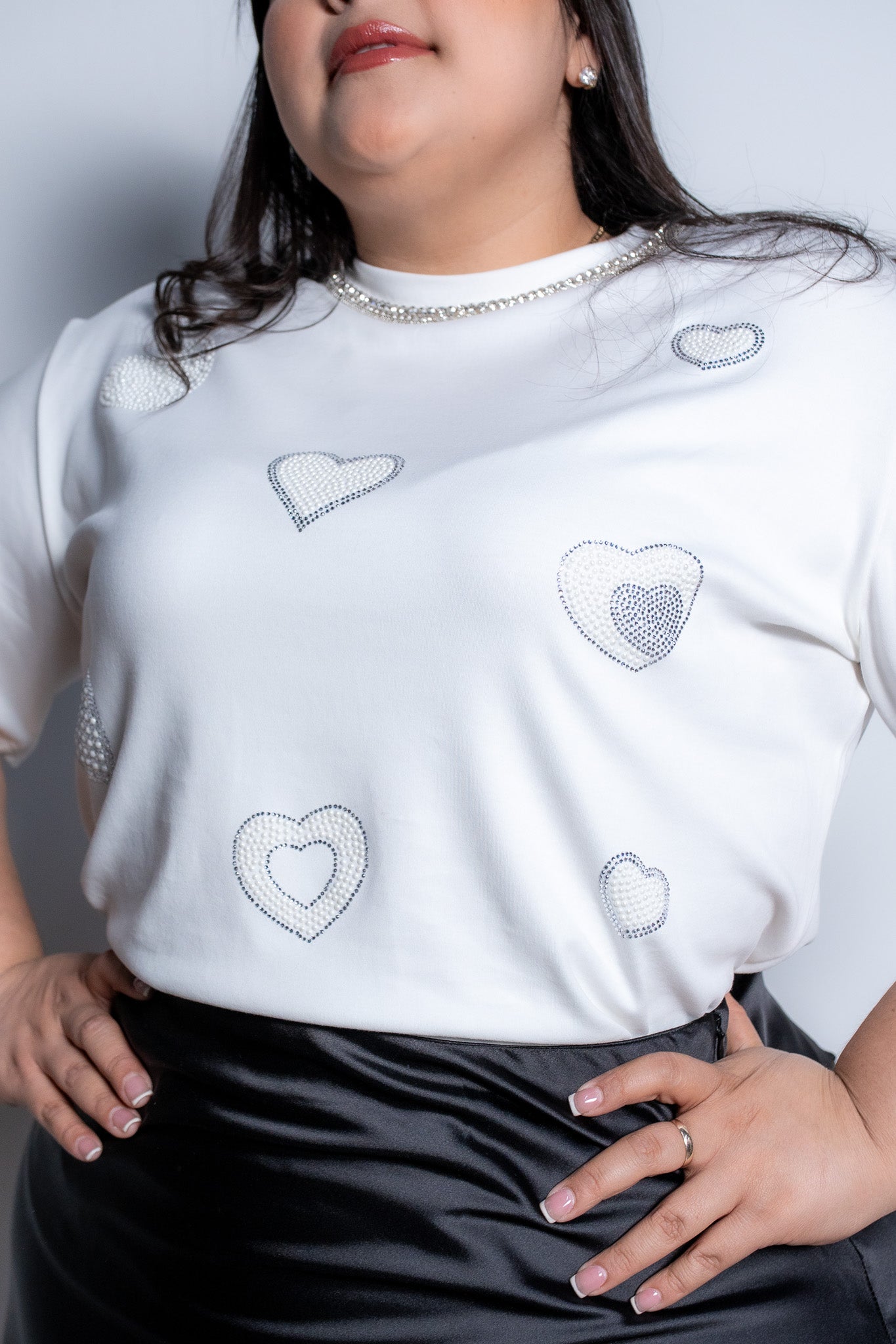 Modelo plus size usando blusa de algodón stretch con aplicación de piedras decorativas, talla extra