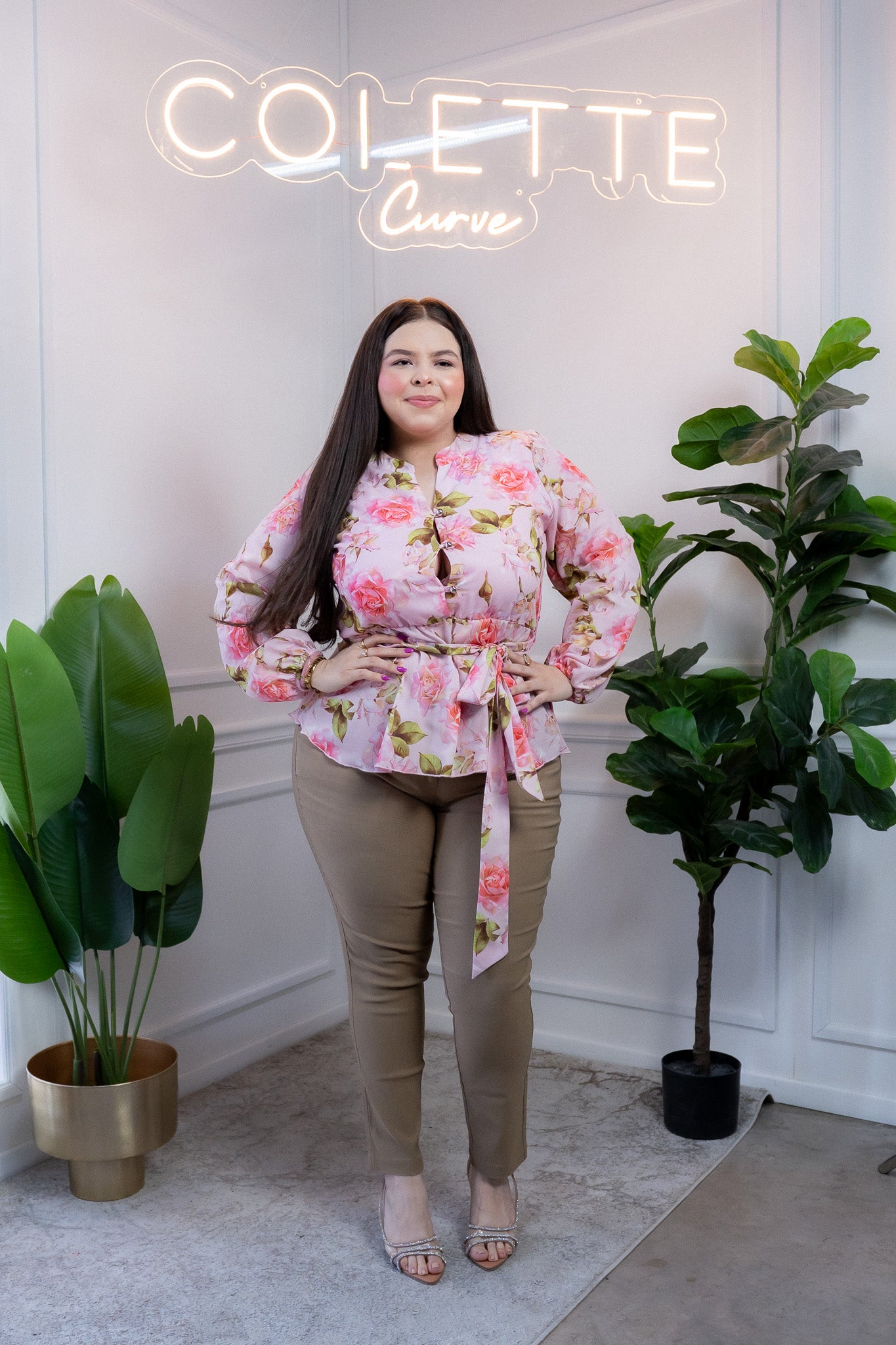Modelo curvy usando blusa peplum rosa con estampado floral, manga larga y elástico en cintura, talla extra plus size
