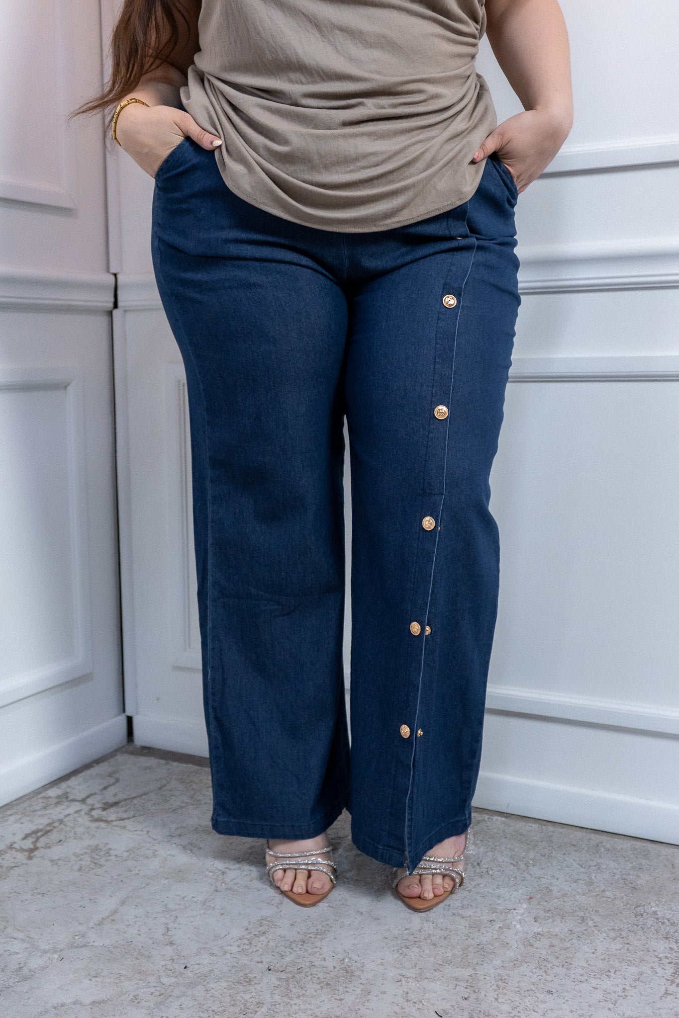 Modelo plus size usando pantalón de mezclilla fluida con botones dorados, talla extra