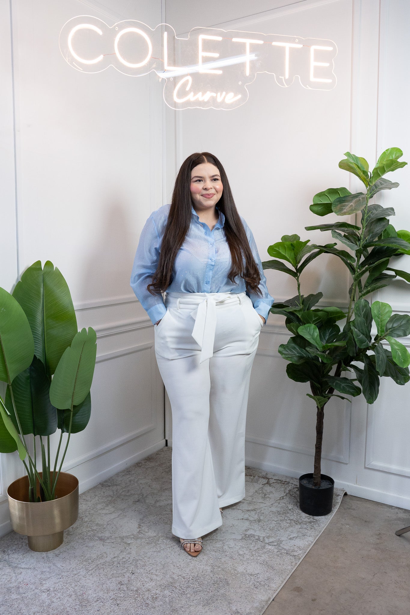 Modelo curvy usando camisa azul con destellos sutiles y manga larga, talla extra plus size