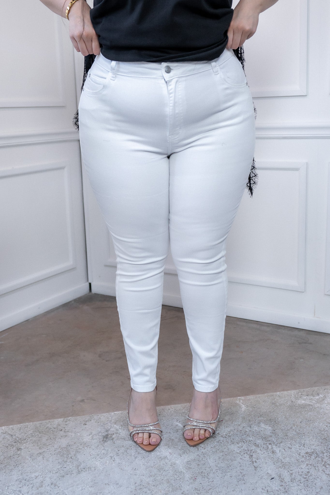 Modelo curvy usando jeans skinny lisos blancos con stretch y cintura alta, talla extra plus size