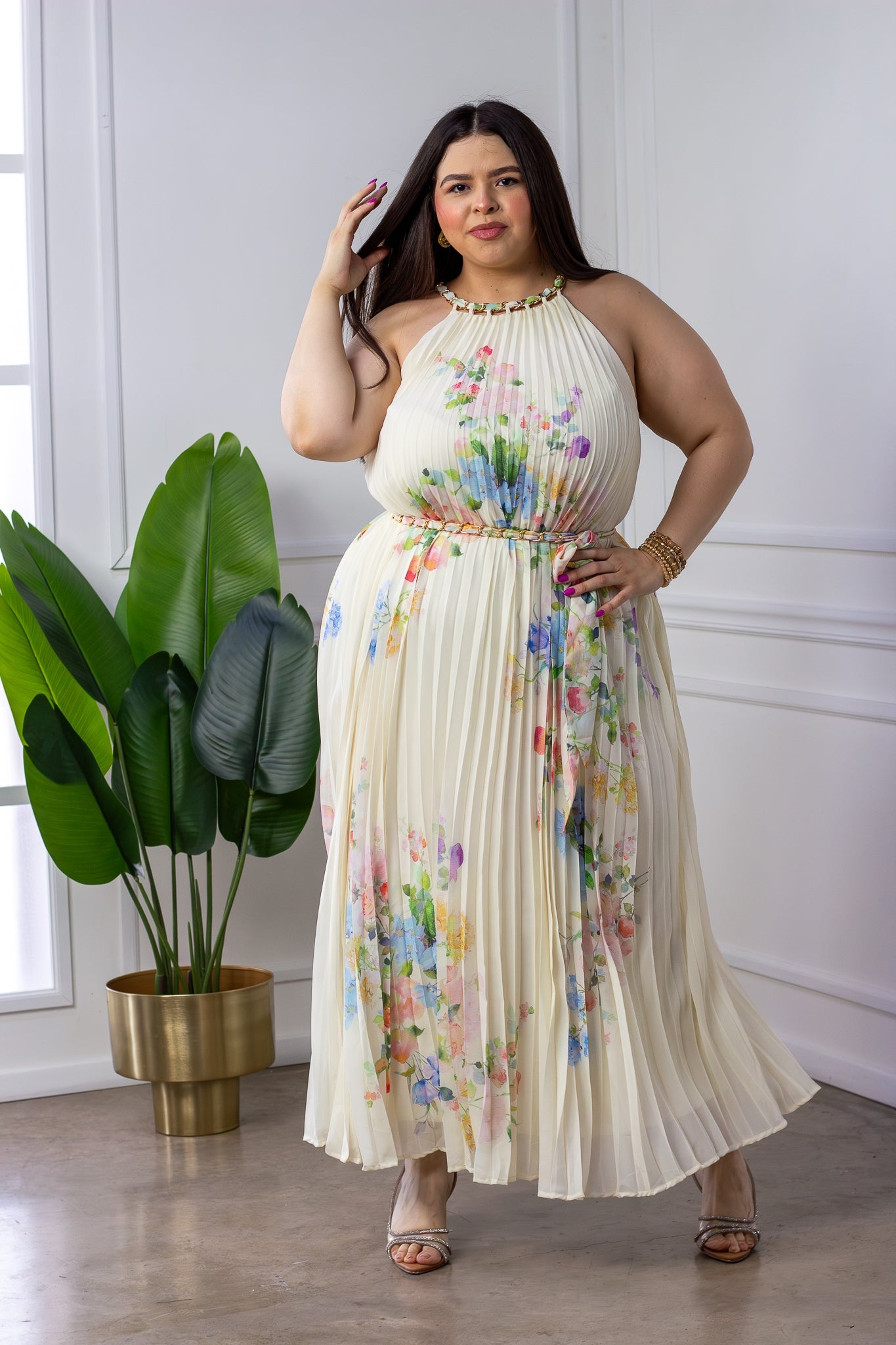 Modelo curvy usando maxi vestido halter plisado en chiffon hueso con estampado floral acuarela y cuello con cadena dorada, talla extra plus size para gala
